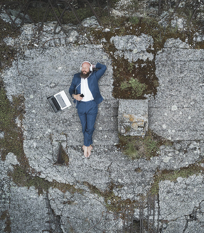 Werbefotografie von Mann im Anzug von oben mit Drohne im Freien